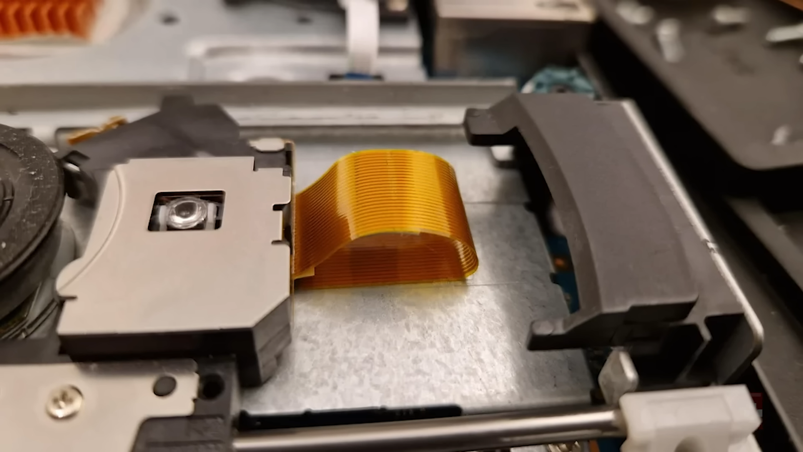 Cabo flat laranja levantado, o culpado pelo PS2 Slim arranhando disco