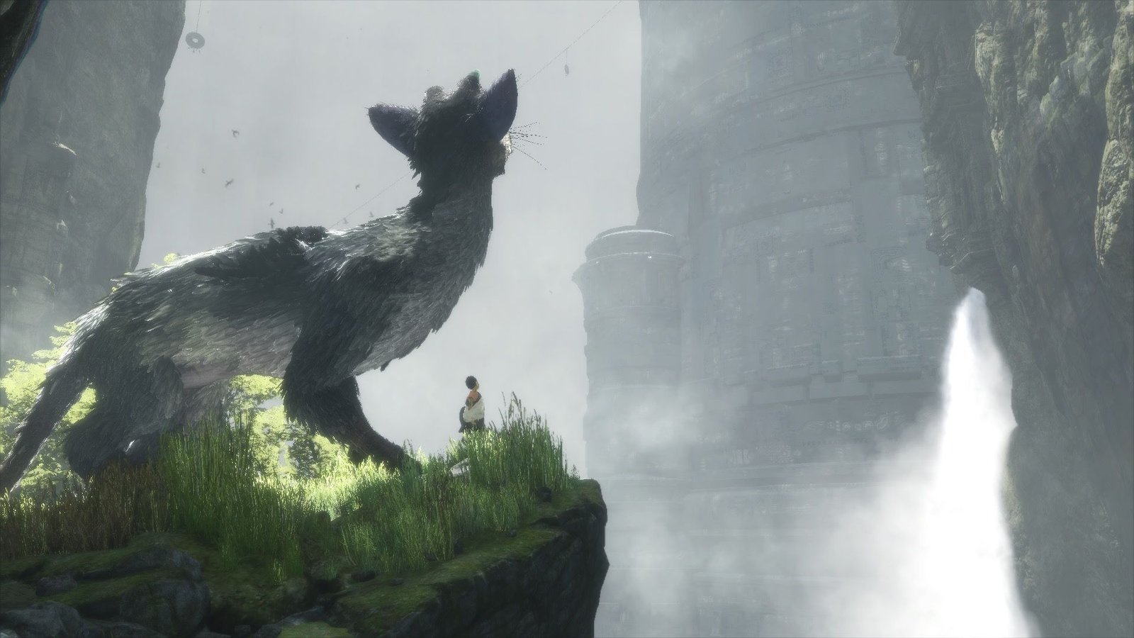 Trico e o menino diante de um penhasco e ruínas enevoadas em The Last Guardian original de PlayStation 4