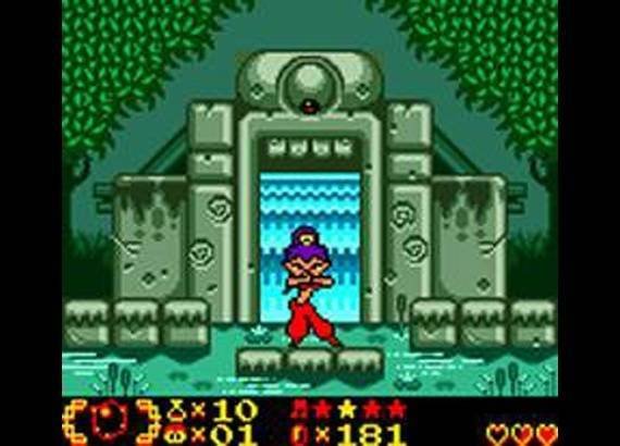 Shantae do Game Boy Color diante de estrutura de pedra e cachoeira no jogo original