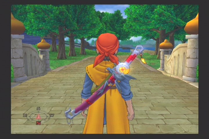 Dragon Quest VIII original mostra o herói visto por trás diante de uma ponte arborizada